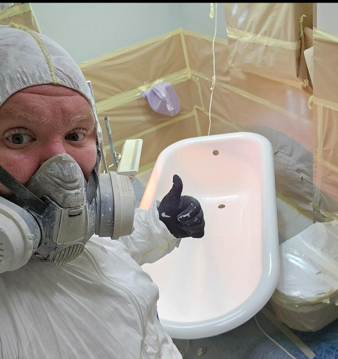 photo of glossy baths owner photo of glossy baths re-enamelling owner Seamus with a thumbs up, in ppe, in a room full of masking up and a completed bath in Bournemouth